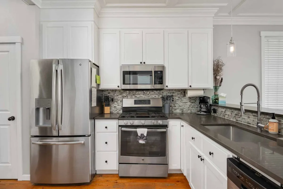 A modern kitchen featuring stainless steel appliances, a granite countertop, and a spacious island. The area is bright and welcoming, ideal for preparing home-cooked feasts or casual breakfasts. The sleek appliances and organized space suggest convenience and culinary creativity.