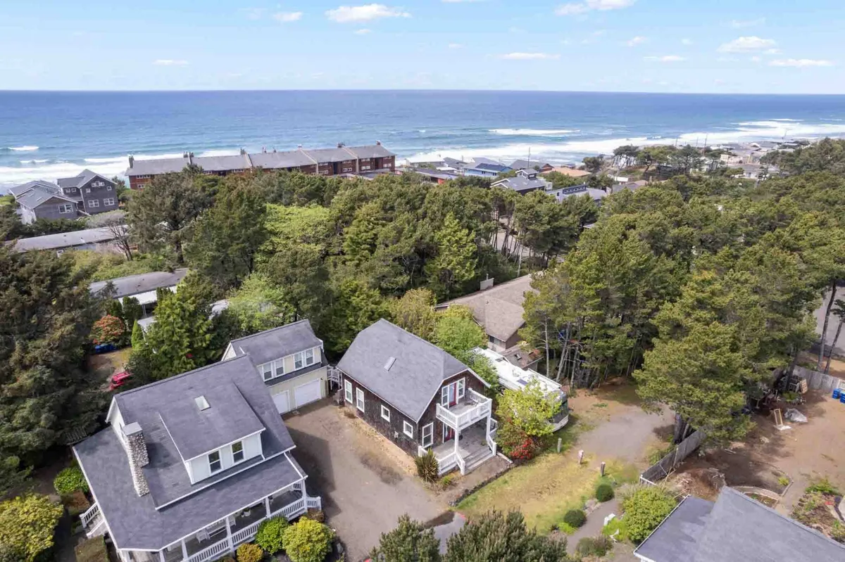 An exterior vantage with panoramic ocean views, lush greenery, and neighboring houses nearby. The scene invites relaxation and wildlife spotting, hinting at nearby nature outings and the tranquility of the area.