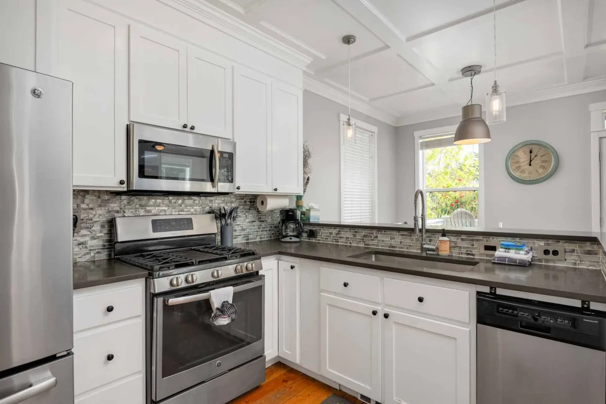 This kitchen scene focuses on stainless steel appliances, a granite countertop, and a window with a view outside. The modern and welcoming kitchen suggests a space for preparing meals after outdoor adventures, with the window hinting at scenic surroundings and natural light.